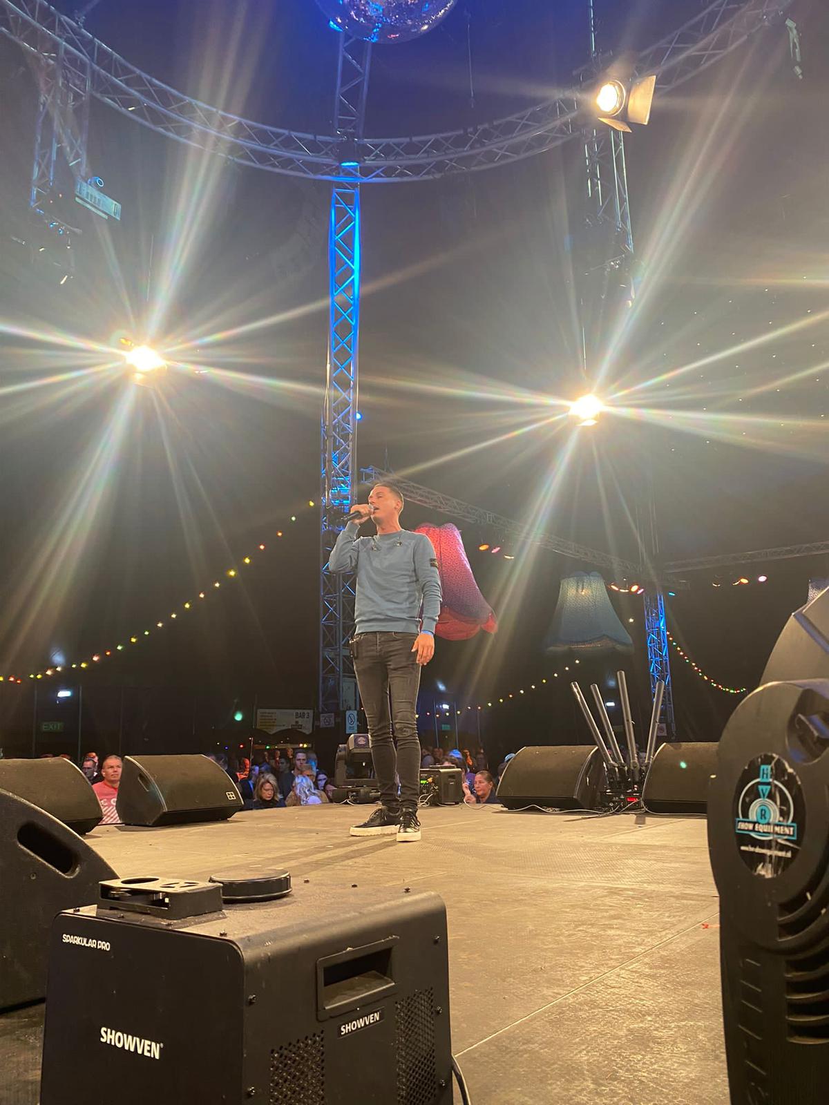 Jermaine Stuiver op een groot podium in een volle feesttent