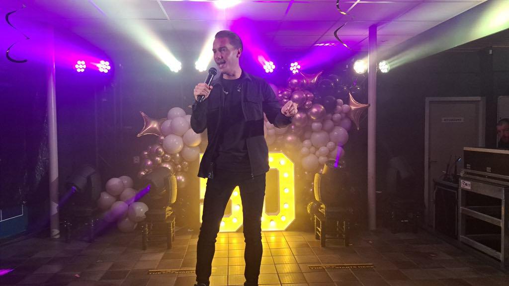 Jermaine Stuiver zingt op het podium in paars en groen podiumlicht